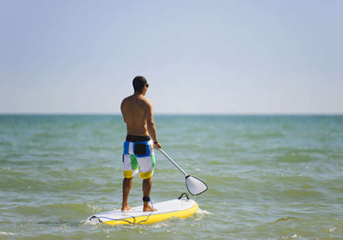 Homem a praticar stand up paddle